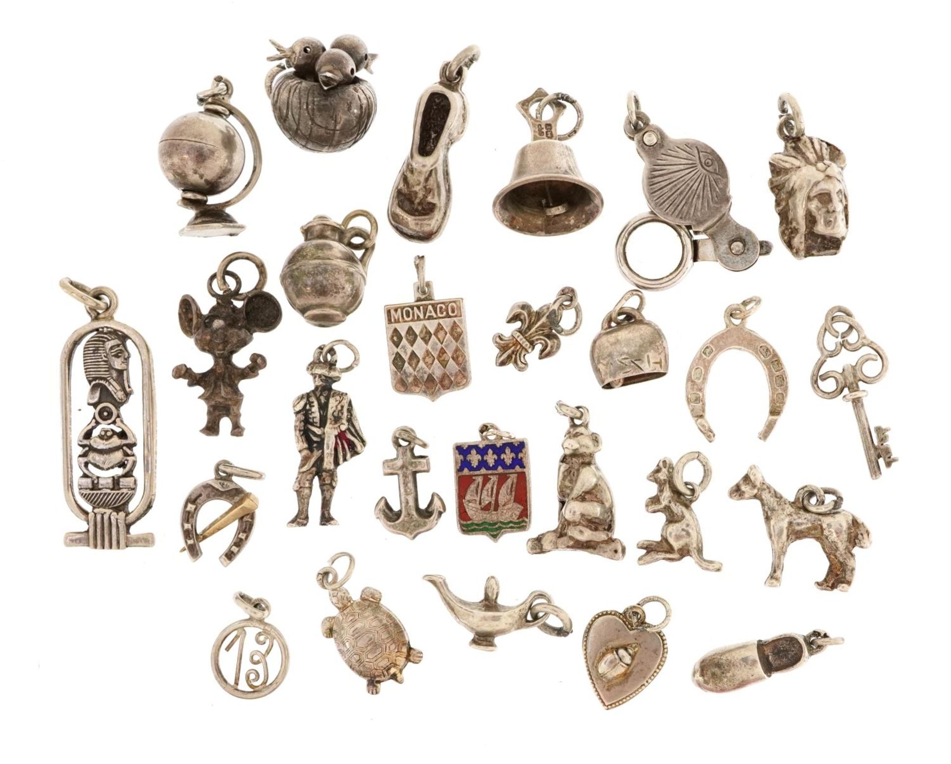 Silver and white metal charms including opening magnifying glass, fleur de lis, enamel bell and