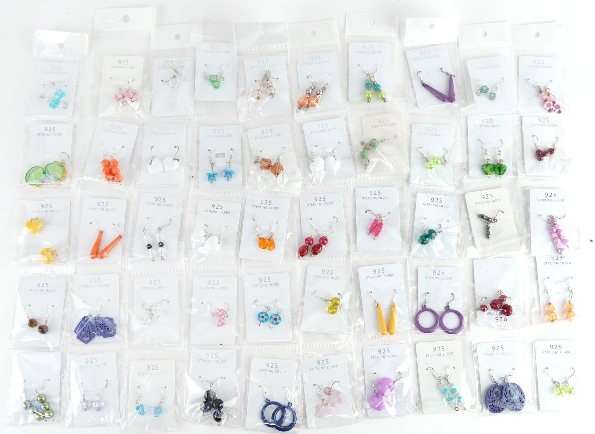Fifty pairs of silver drop earrings including star and floral design examples, total approximately