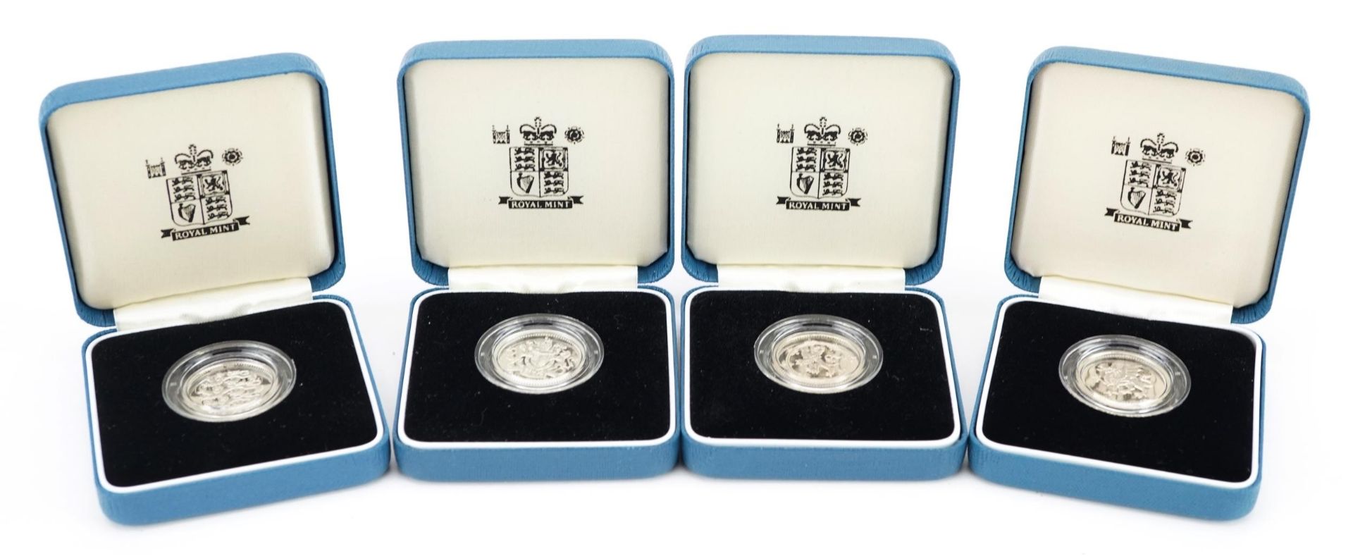 Four United Kingdom silver proof one pound coins by The Royal Mint with certificates and cases