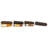 Three early 20th century cigarette holders with amber coloured mouthpieces, two with silver