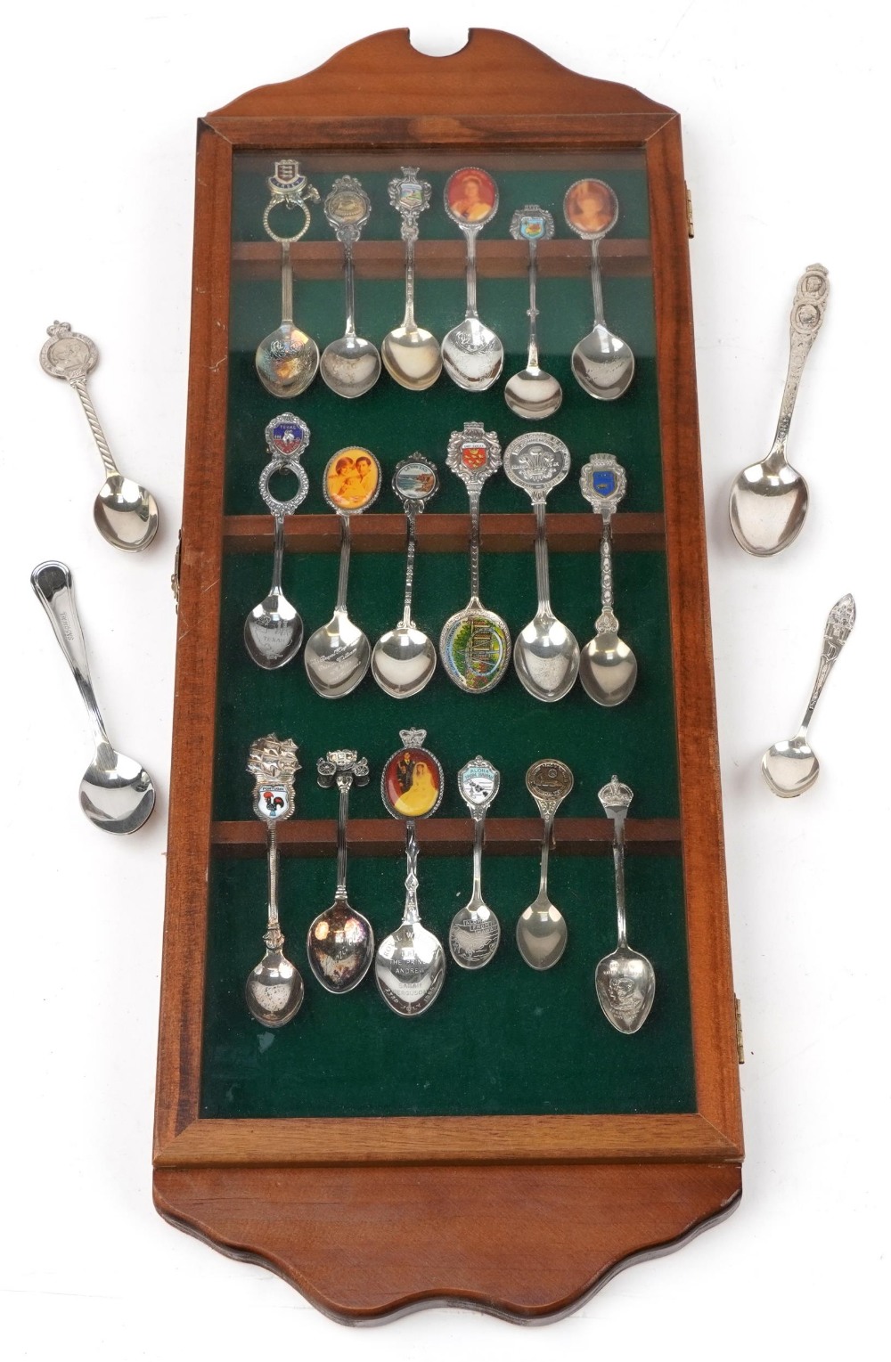 Collection of souvenir and commemorative spoons housed in a display case including two silver