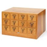 Industrial light oak slope front haberdashery twelve drawer filing chest with Libraco London plaque,