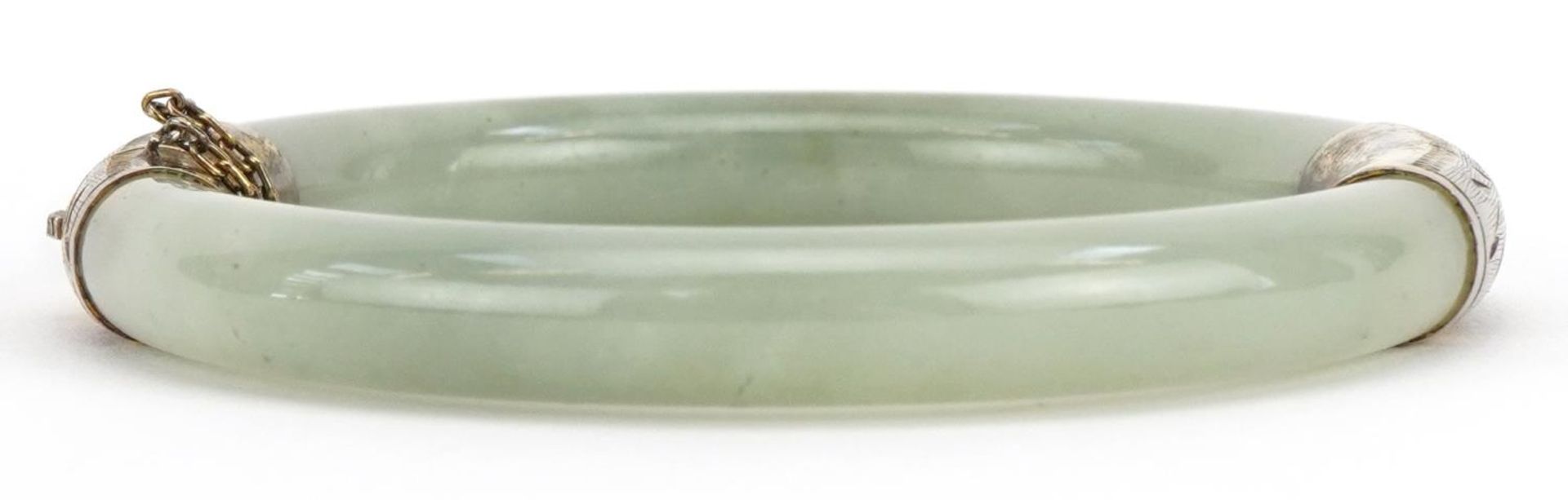 Chinese green jade hinged bangle with silver gilt mounts, 7cm in diameter : For further