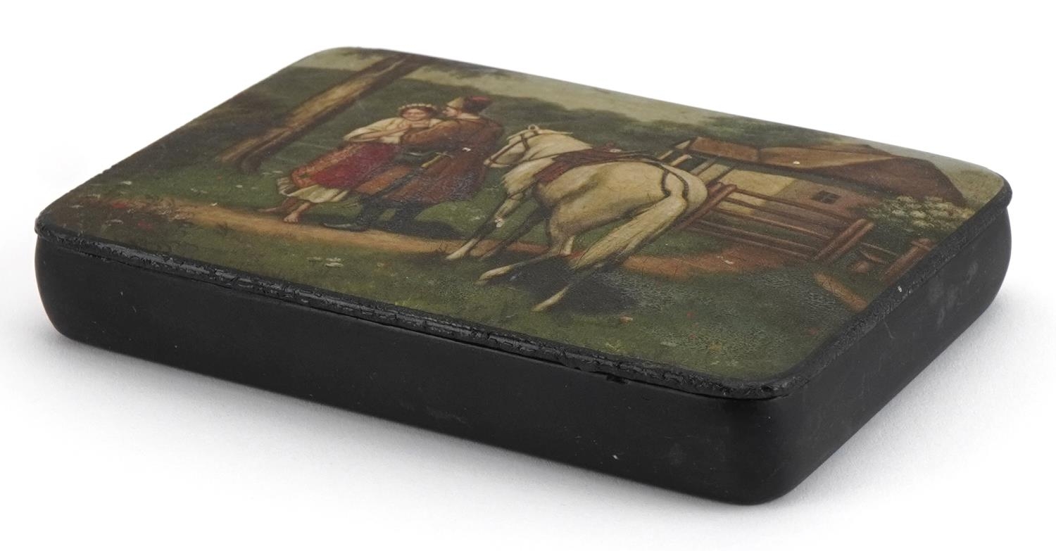 Russian papier mache lacquered cigarette box with hinged lid, hand painted with a Cossack and