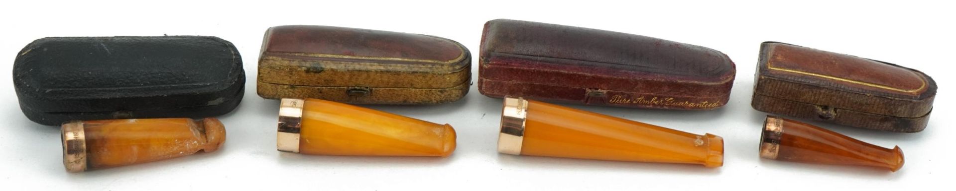 Four late19th/early 20th century butterscotch amber cigarette holders with 9ct gold mounts, each