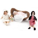 Four vintage dolls and a wicker crib including a bisque headed Armand Marseille example numbered 390