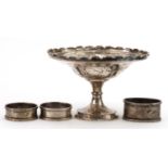 James Walker, circular silver pedestal dish and three silver napkin rings, the largest 13.5cm in