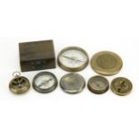 Four compasses including one with case and a maritime interest example, the largest 7.5cm in