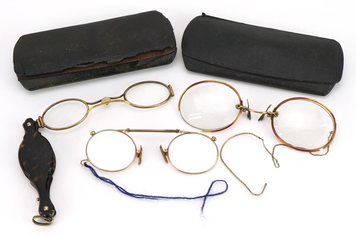 Three pairs of early 20th century spectacles comprising one with tortoiseshell handle and two yellow