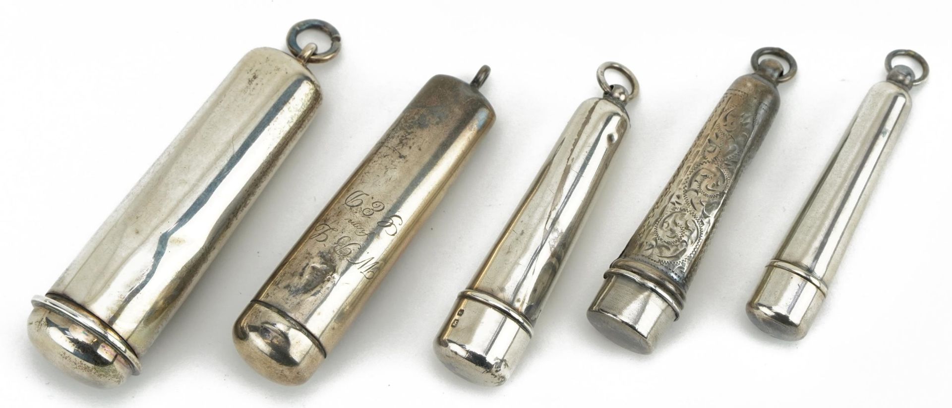 Five Edwardian and later silver cigarette holder cases, one with engraved decoration, various