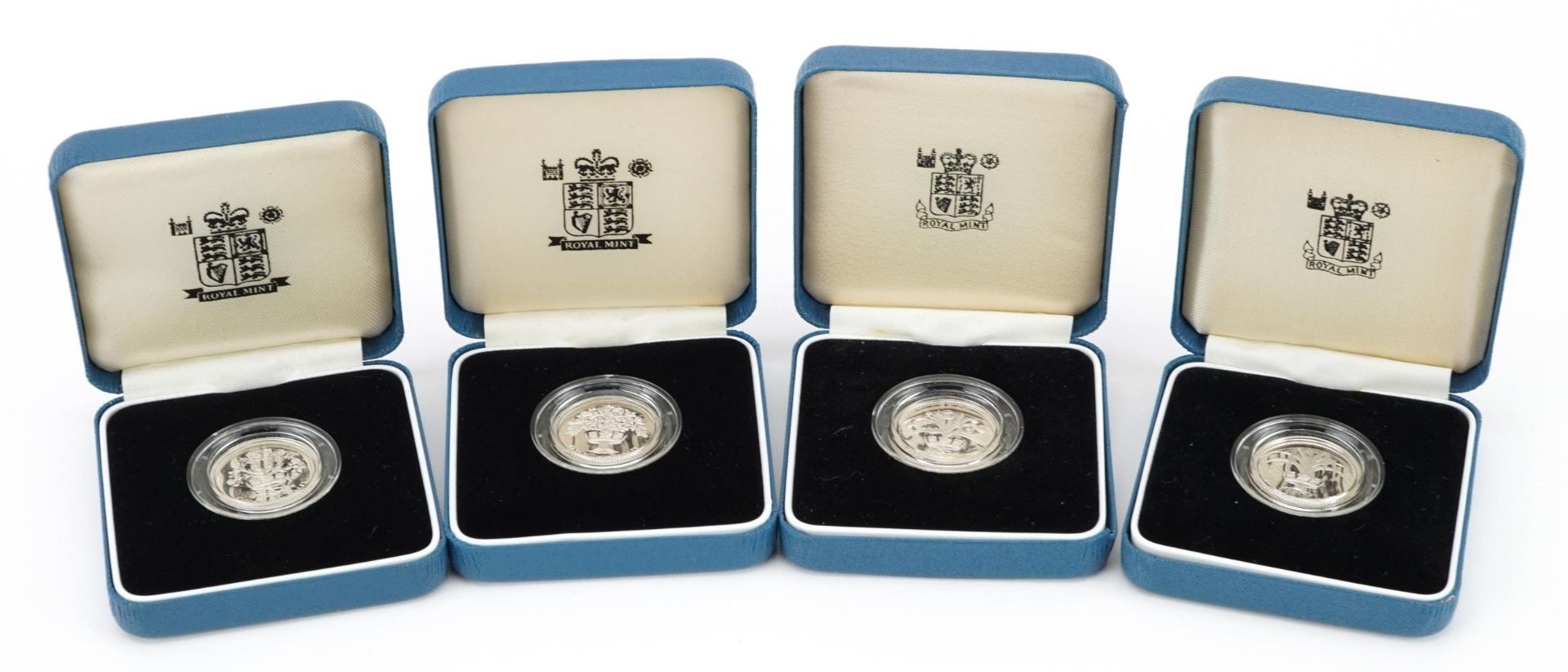 Four United Kingdom silver proof one pound coins by The Royal Mint with certificates and cases