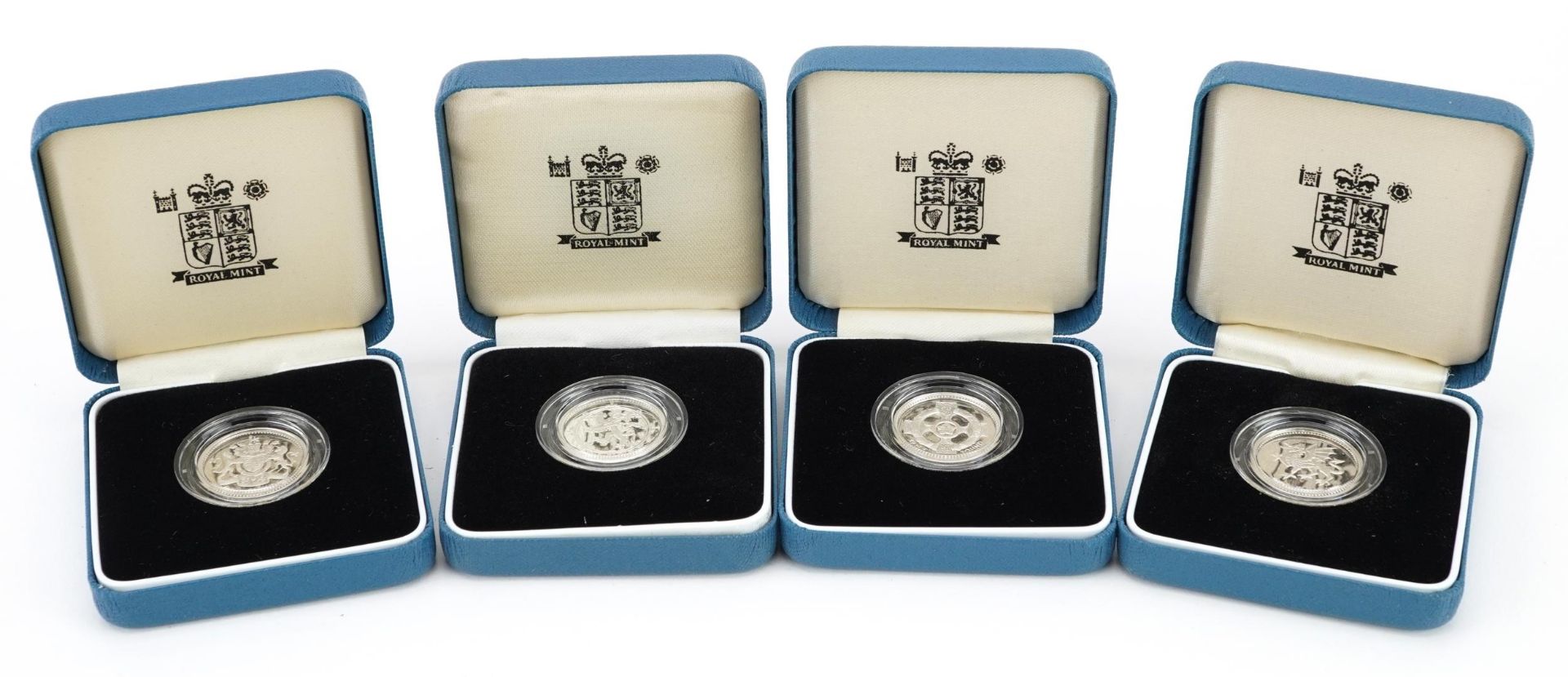 Four United Kingdom silver proof one pound coins by The Royal Mint with certificates and cases