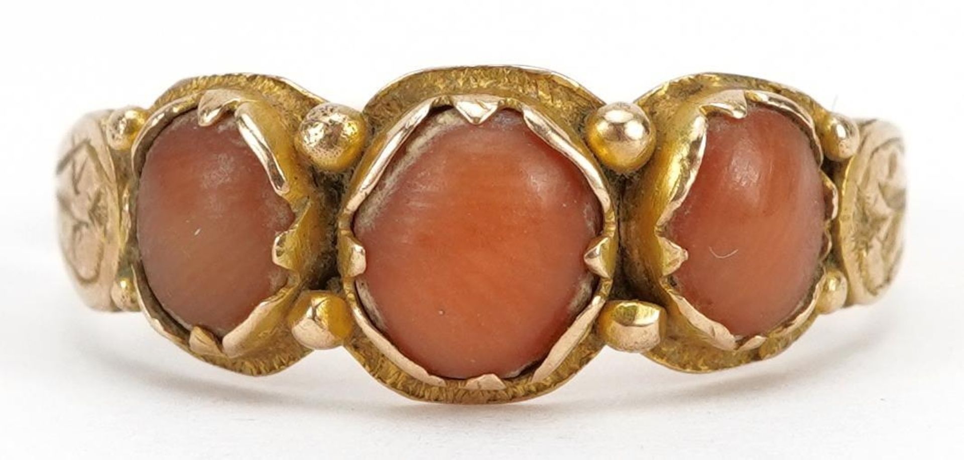 Antique unmarked gold coral three stone ring with engraved shoulders, tests as 15ct gold, size P,