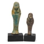 Two Egyptian style shabtis raised on painted wooden block bases, the largest overall 12cm high