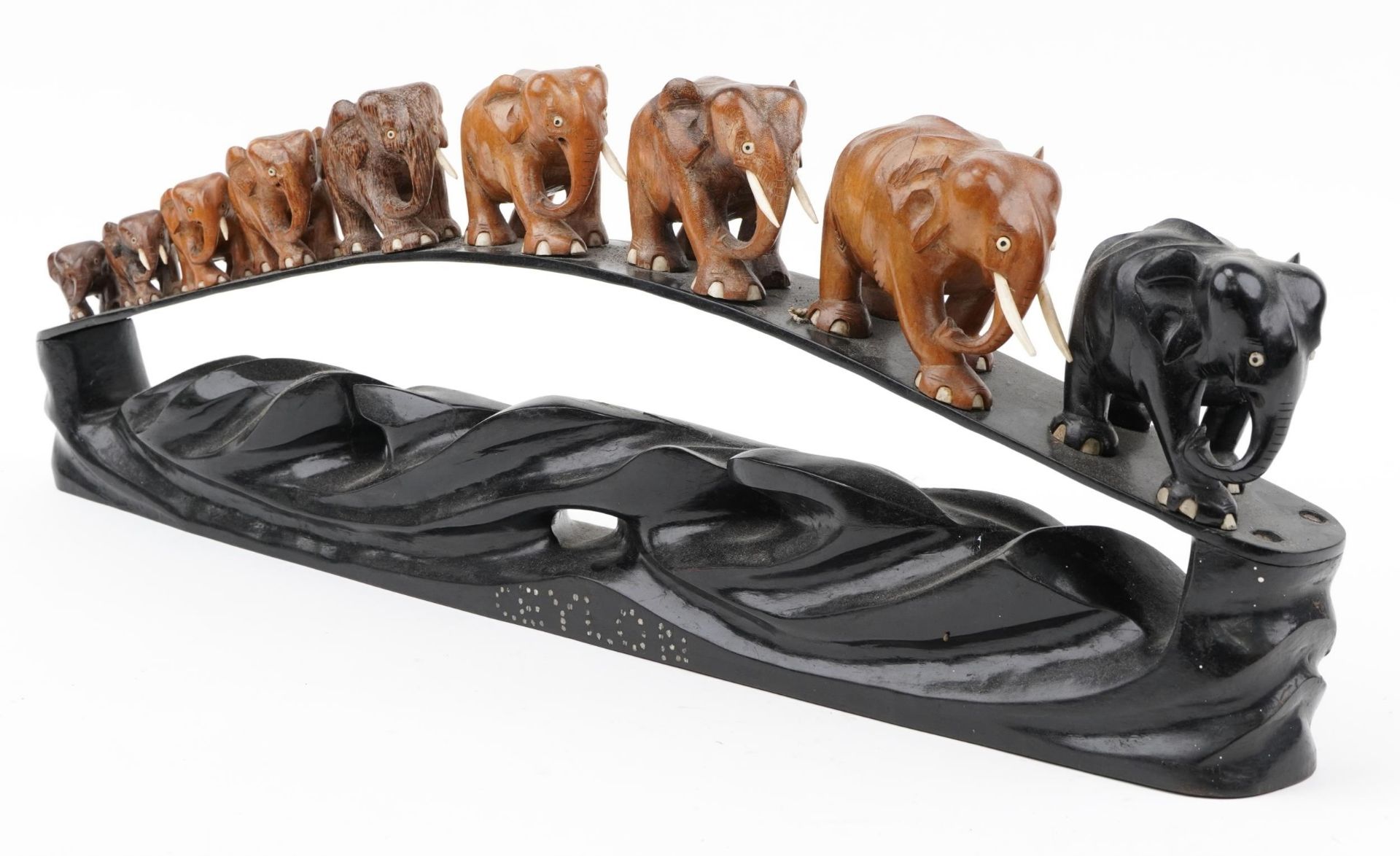 African ebony stand surmounted with nine graduated hardwood elephants, the stand inlaid Ceylon, 78cm