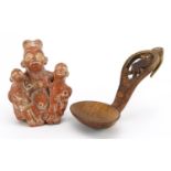 Peruvian terracotta figure group of a nude mother and two children and a Scandinavian treen spoon,
