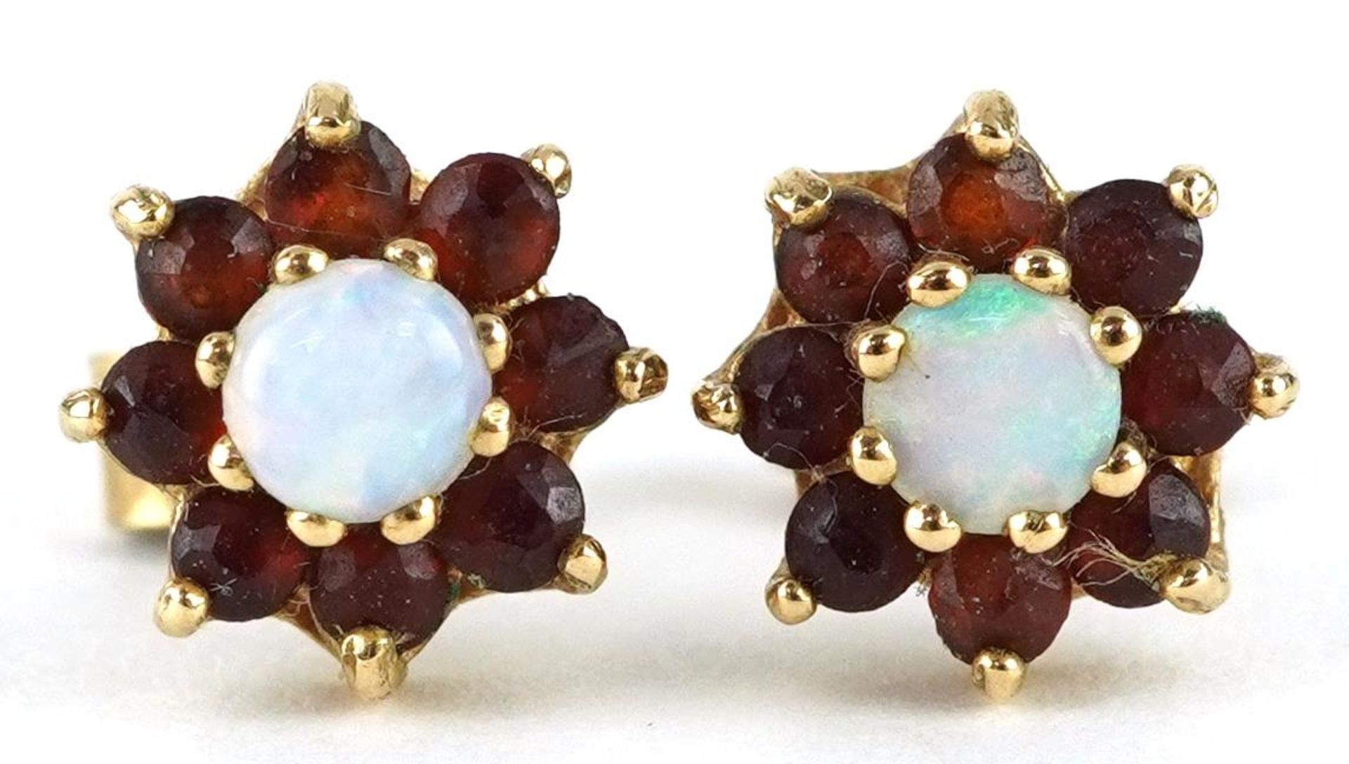 Pair of 9ct gold opal and garnet flower head stud earrings, 9.0mm in diameter, 1.5g