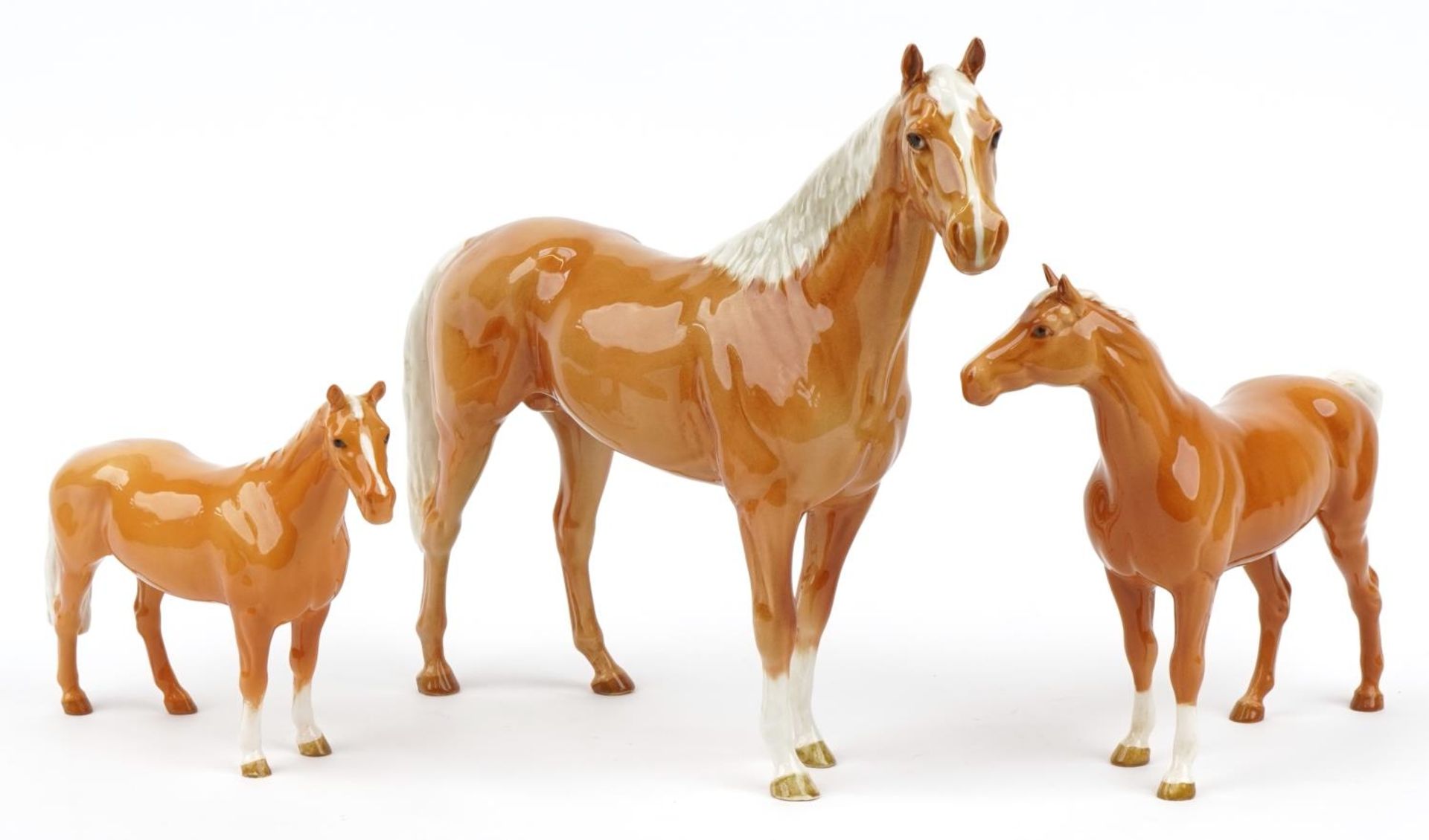 Three graduated Beswick tan horses, the largest 35cm in length