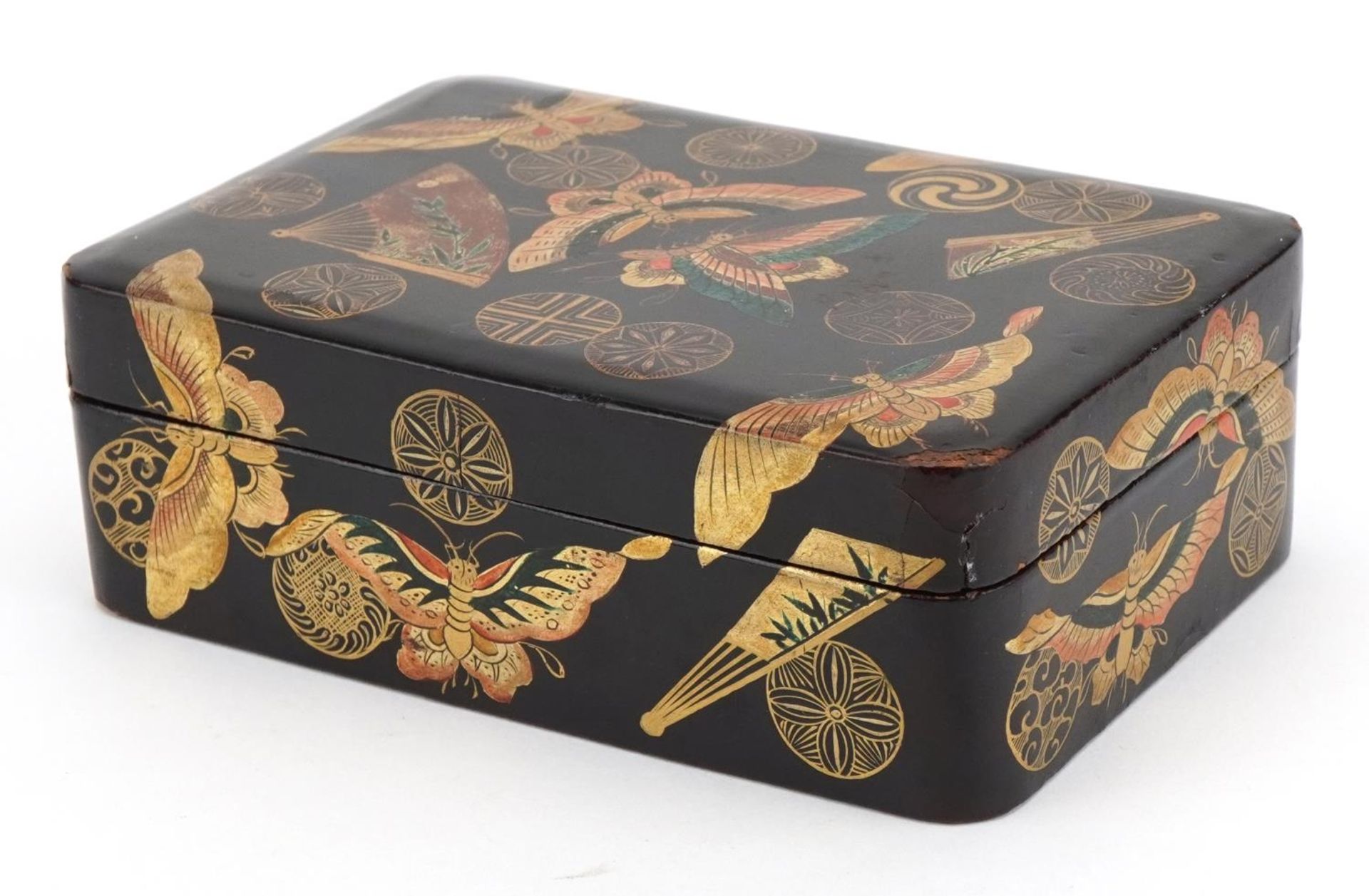 Japanese lacquered box and cover gilded with butterflies amongst fans and stylised roundels, 5cm x