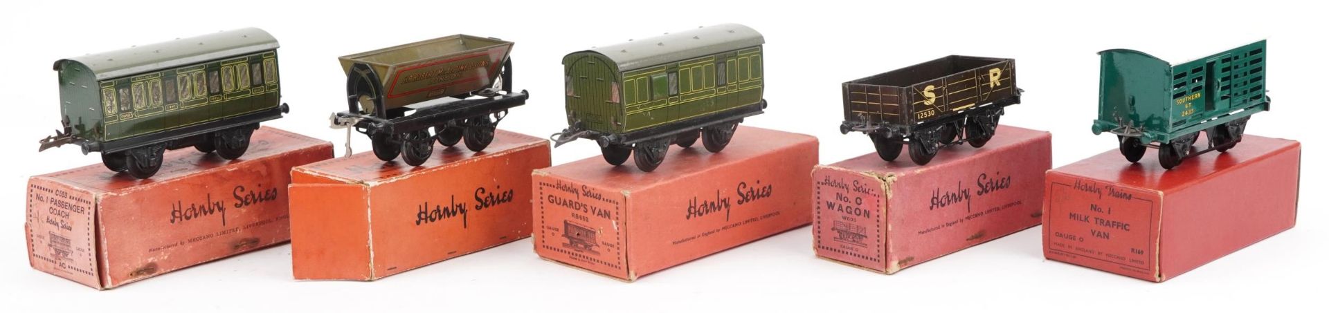 Five Hornby O gauge tinplate model railway wagons with boxes comprising passenger coach guards