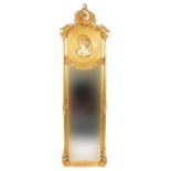 Large ornate gilt framed wall mirror with bevelled glass and relief panel of a maiden, 180cm x 53cm