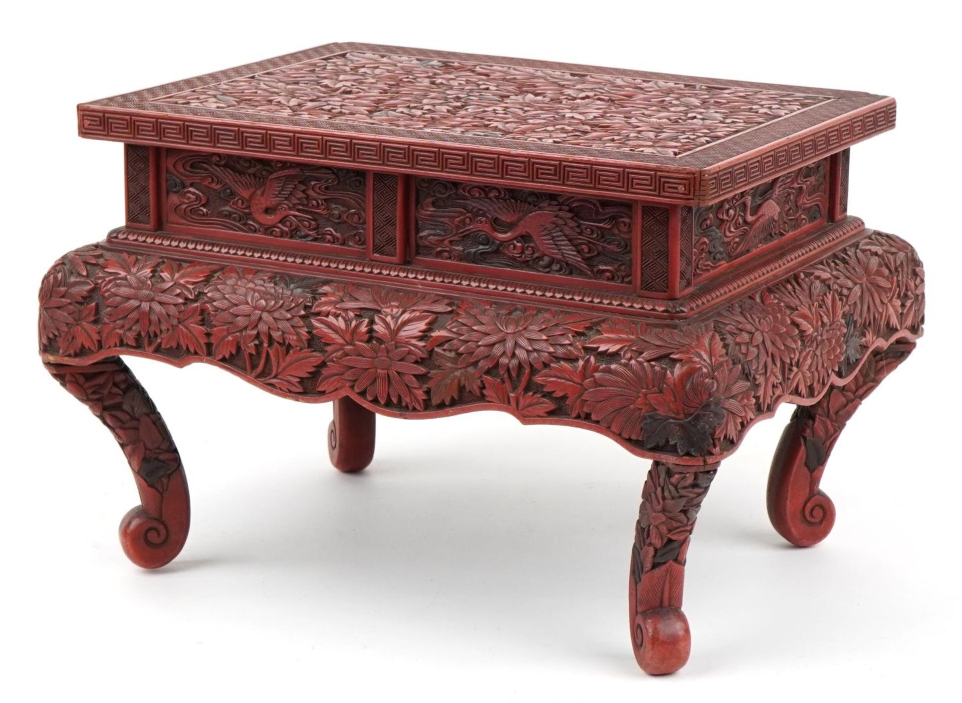 Large Chinese cinnabar lacquered stand profusely carved with chrysanthemums and phoenixes, 26cm H