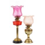 Two Victorian brass oil lamps including an example with reeded column and cranberry glass shade, the
