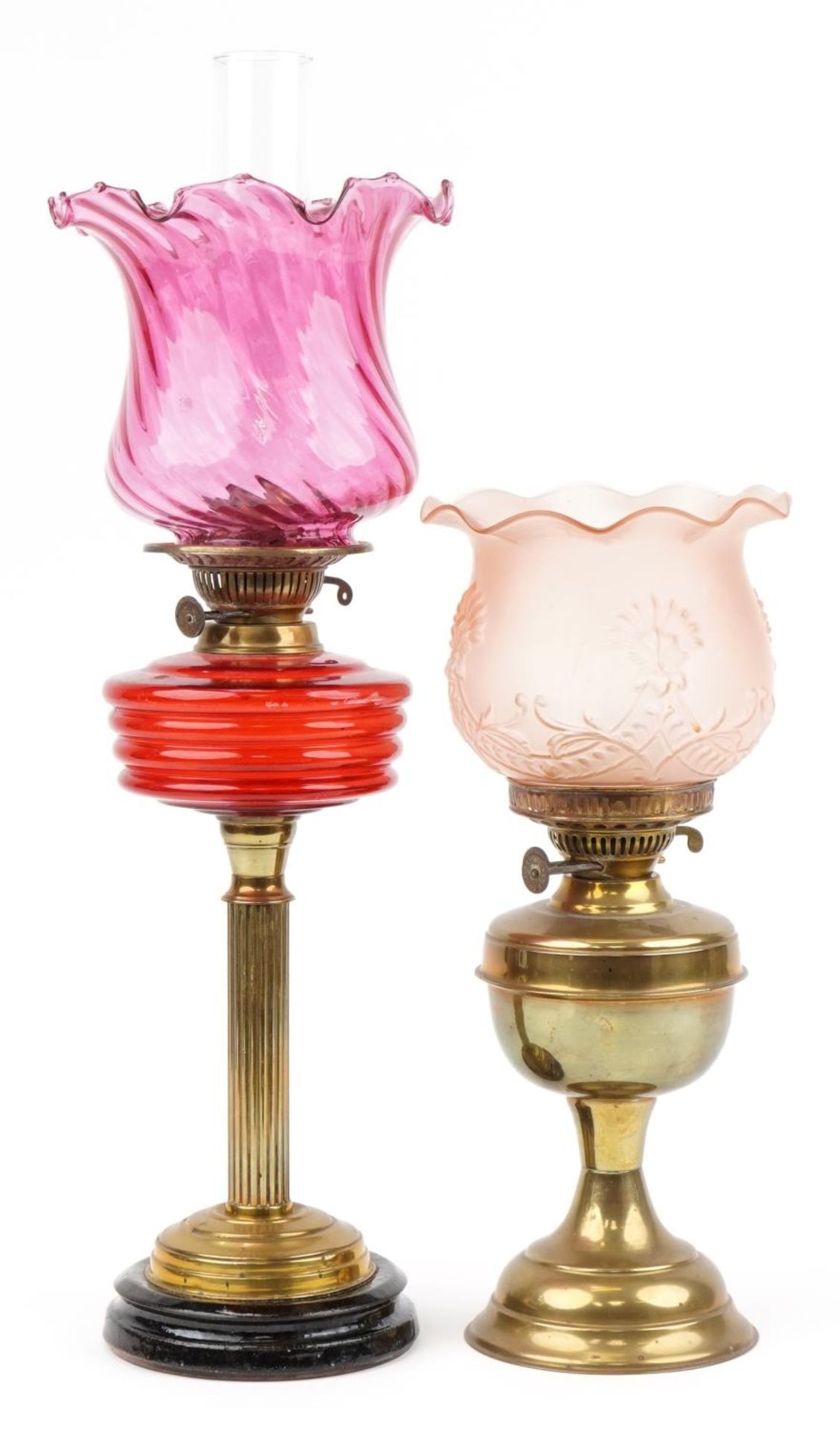 Two Victorian brass oil lamps including an example with reeded column and cranberry glass shade, the