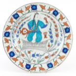 Turkish Ottoman Iznik plate hand painted with a figure and stylised flowers, 32cm in diameter