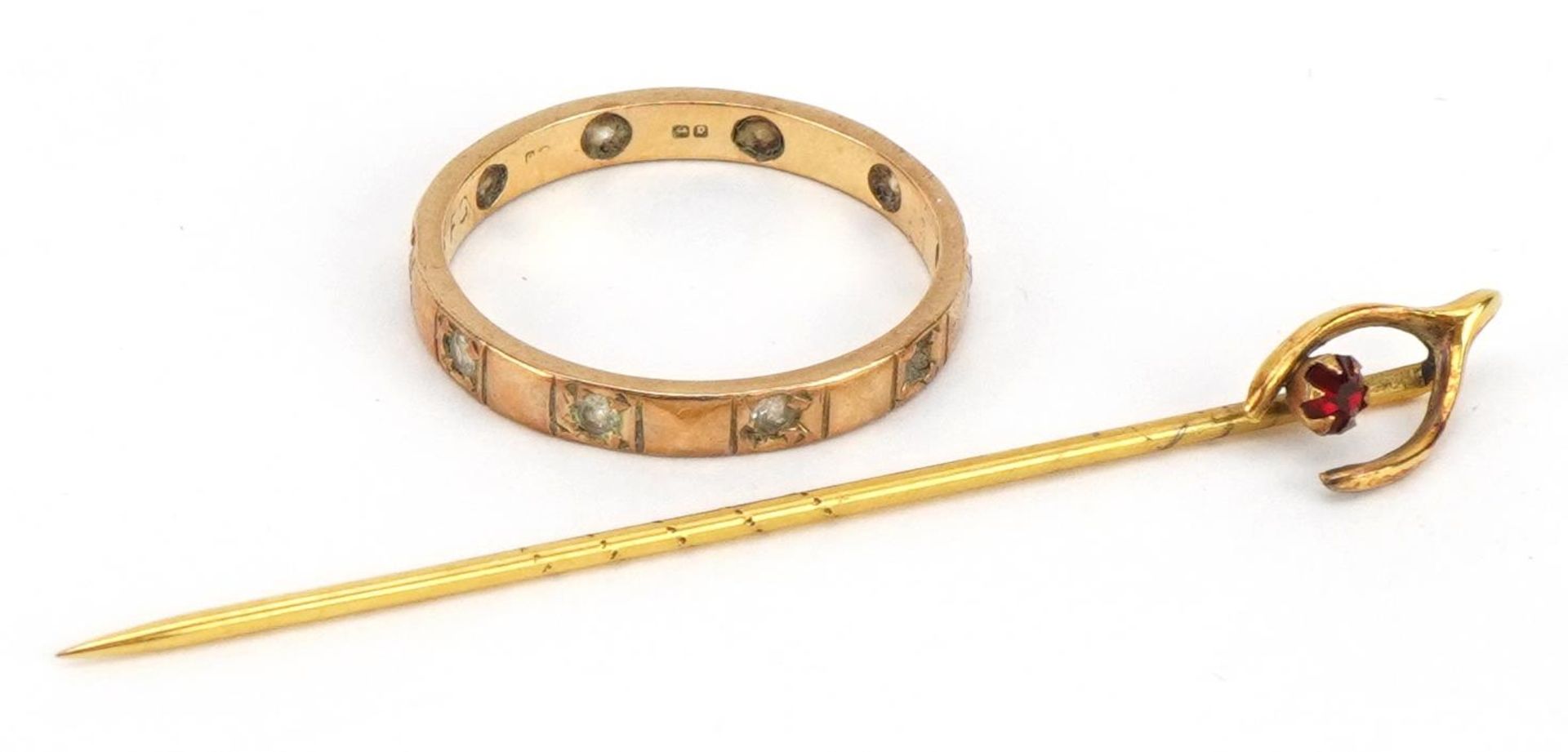 9ct gold clear stone eternity ring and an unmarked gold wishbone stickpin set with a red stone,