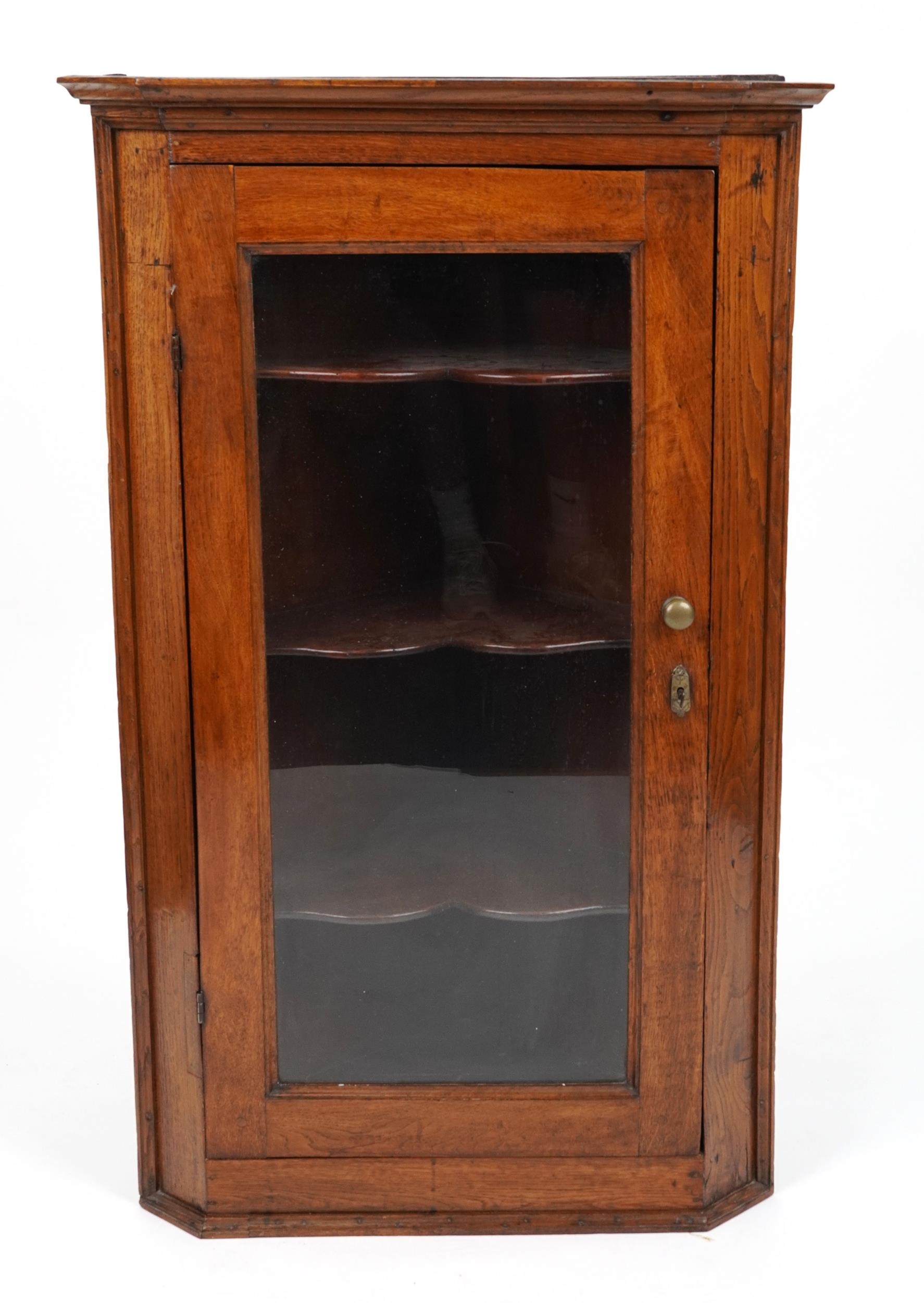 Antique oak wall hanging corner cabinet with glazed door enclosing three shelves, 113cm H x 70cm W x