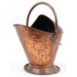 Planished copper helmet shaped scuttle with swing handle, 40cm high excluding the handle