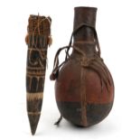 Tribal interest African leather bound wood gourd and one other, the largest 40cm high