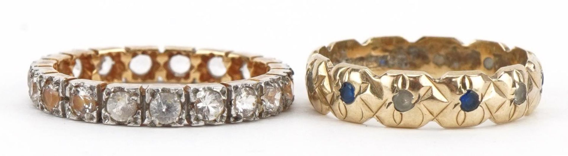 Two unmarked gold eternity rings set with clear and blue stones, test as 9ct gold, sizes N and L,