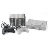 Sony PlayStation 1 games console with controllers and a collection of games