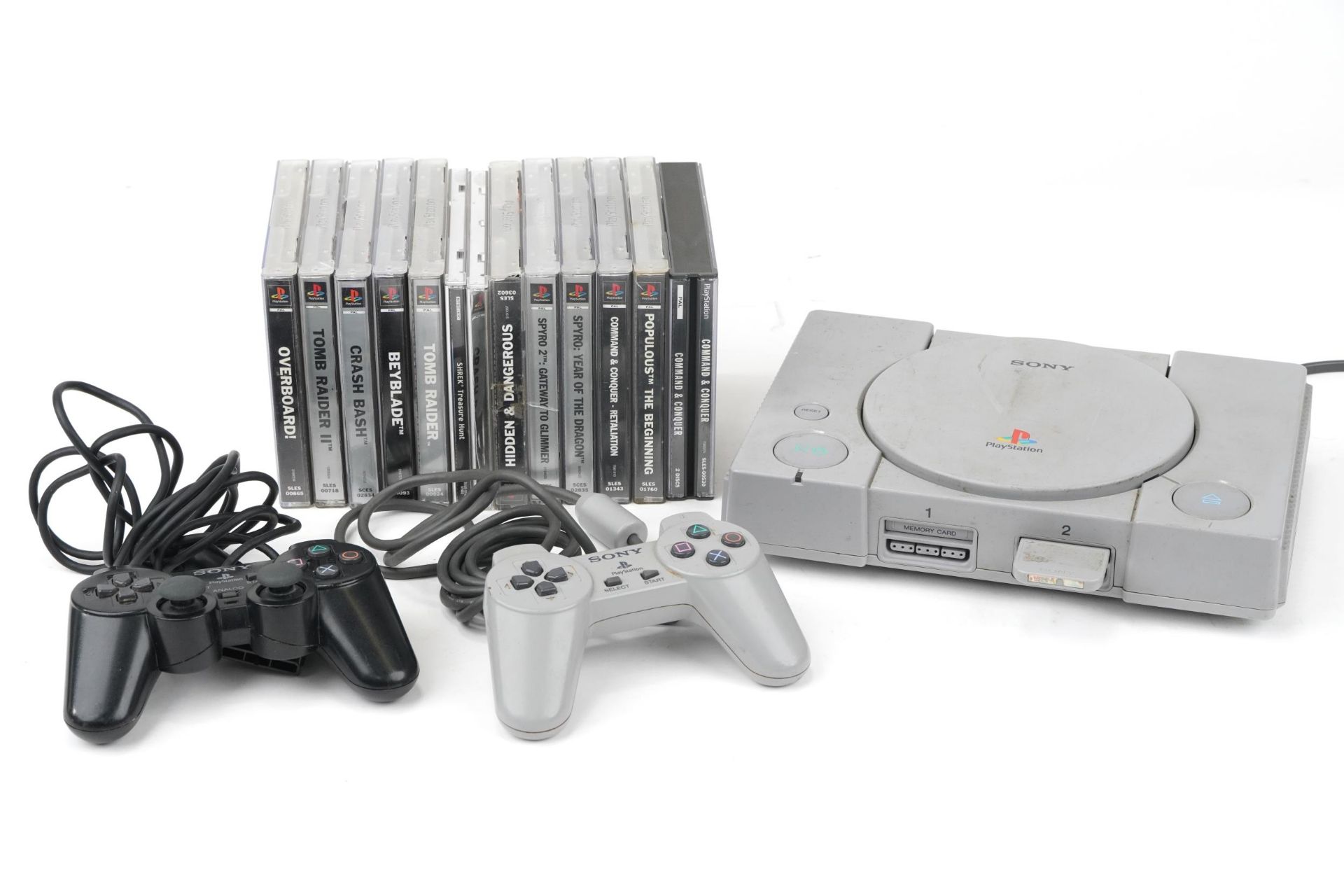 Sony PlayStation 1 games console with controllers and a collection of games