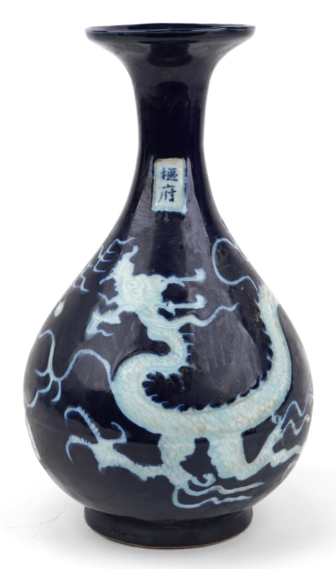 Chinese porcelain vase having a blue glaze decorated in low relief with a dragon chasing the flaming