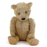 Old golden straw filled teddy bear with jointed limbs