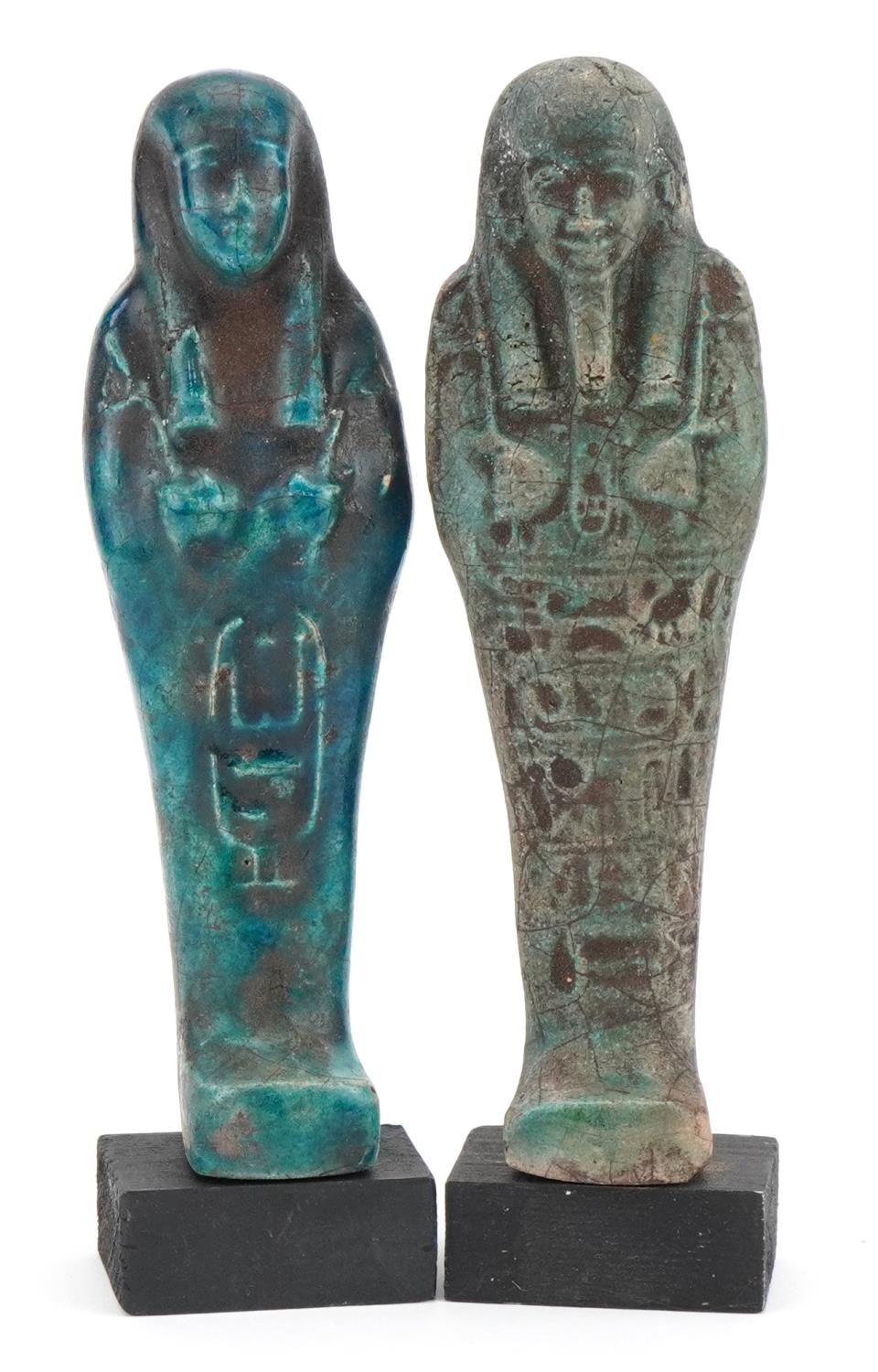 Two Egyptian style shabtis raised on painted wooden block bases, each 18.5cm high