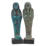 Two Egyptian style shabtis raised on painted wooden block bases, each 18.5cm high