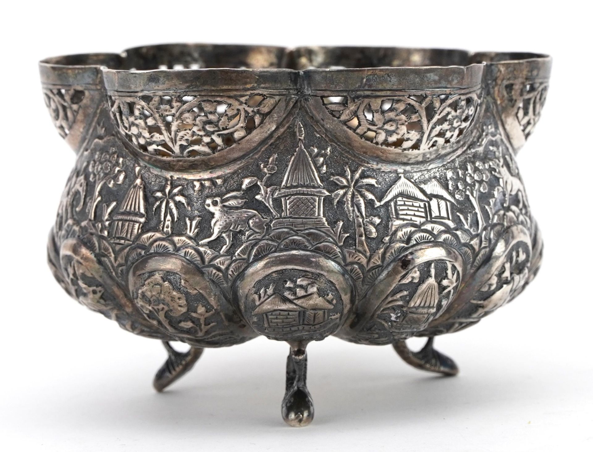 Anglo Indian unmarked silver three footed bowl embossed with wild animals and huts, 10cm in