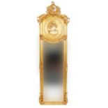 Large ornate gilt framed wall mirror with bevelled glass and relief panel of a maiden, 180cm x 53cm