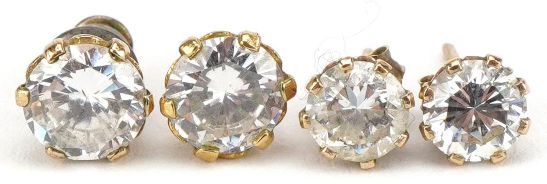 Two pairs of unmarked gold clear stone stud earrings, the largest 7mm in diameter, total 2.0g