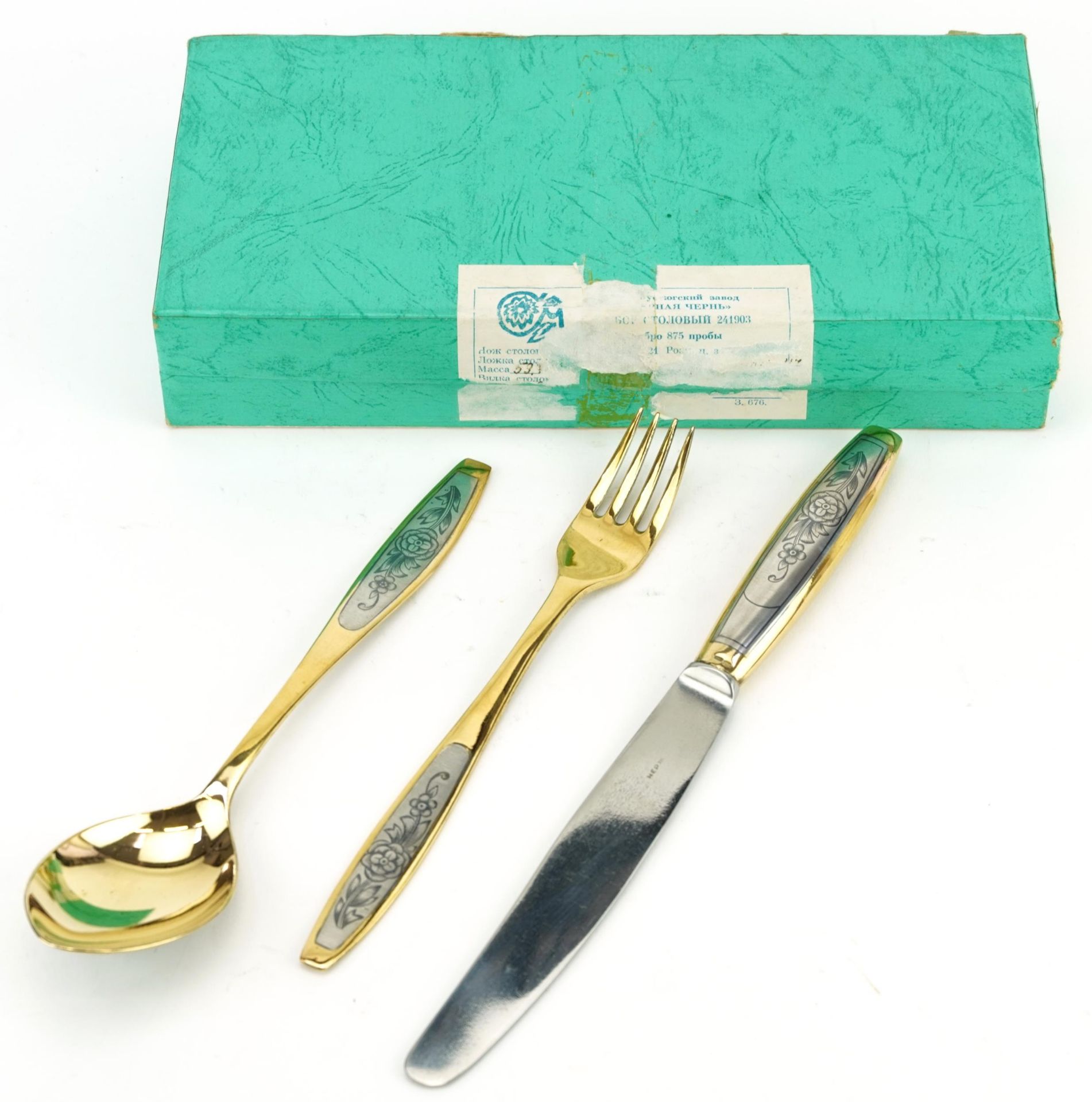 Russian partially gilt silver niello work knife, fork and spoon set housed in a fitted box, the