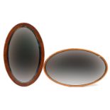 Two 19th century oval wall mirrors with bevelled glass including an oak framed example, the