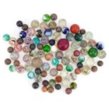 Collection of 19th century and later glass marbles including latticinio examples, the largest