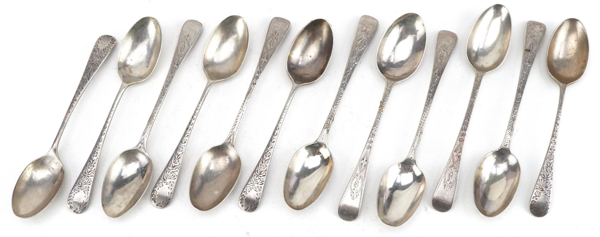Twelve Georgian and later silver teaspoons engraved with foliage, the largest 13cm in length,