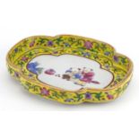 Chinese porcelain four footed dish with yellow ground border hand painted in the famille rose