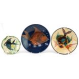 Three art pottery plates hand painted with stylised fish including one by Puigdemont, the largest