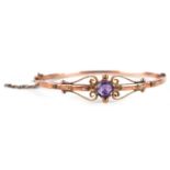 Edwardian 9ct rose gold amethyst bangle with scrolled decoration, the amethyst approximately 6.6mm